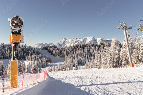 Austria, Styria, Schladming, Snow machine and ski lift at Planai ski slope photo