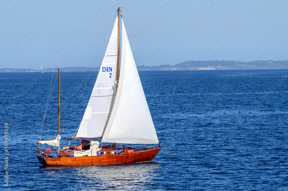 Man in wooden sailboat at Aarhus bay, Denmark on 24 June 2020
