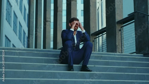Sad furious office executive throwing his suitcase been fired lost job sitting on stairs frustrating. Unhappy fired businessman. Unemployment after lockdown. Crisis.