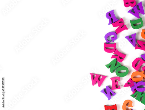 multicolored English alphabet letters and school supplieson a white background.