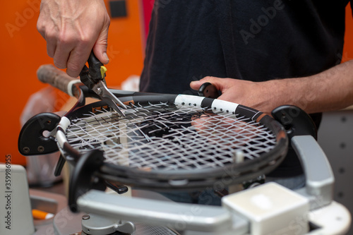 Process of stringing a tennis racket in a tennis shop, sport and leisure concept
