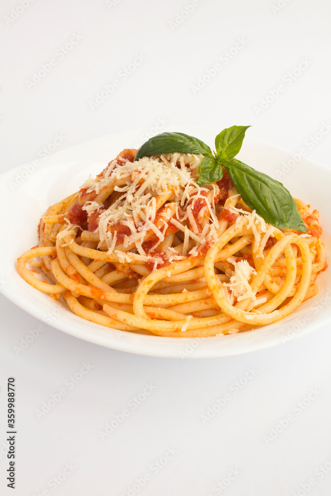 Italian pasta with tomato sauce and parmesan in the plate on the white background. Copy space. Location vertical. Italian pasta with tomato sauce and parmesan in the plate on the white background. Copy space. Location vertical.
