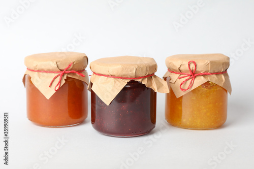 Glass jars with jam on white background. Sweet food