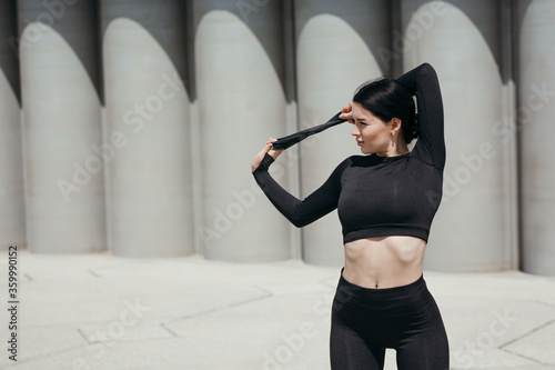 beautiful Asian woman doing an exercise for the back with a sports rubber expander to strengthen the trapezius muscles