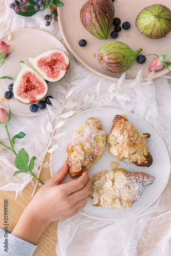 A Child's Hand Eating Snacks Almond Croissants
