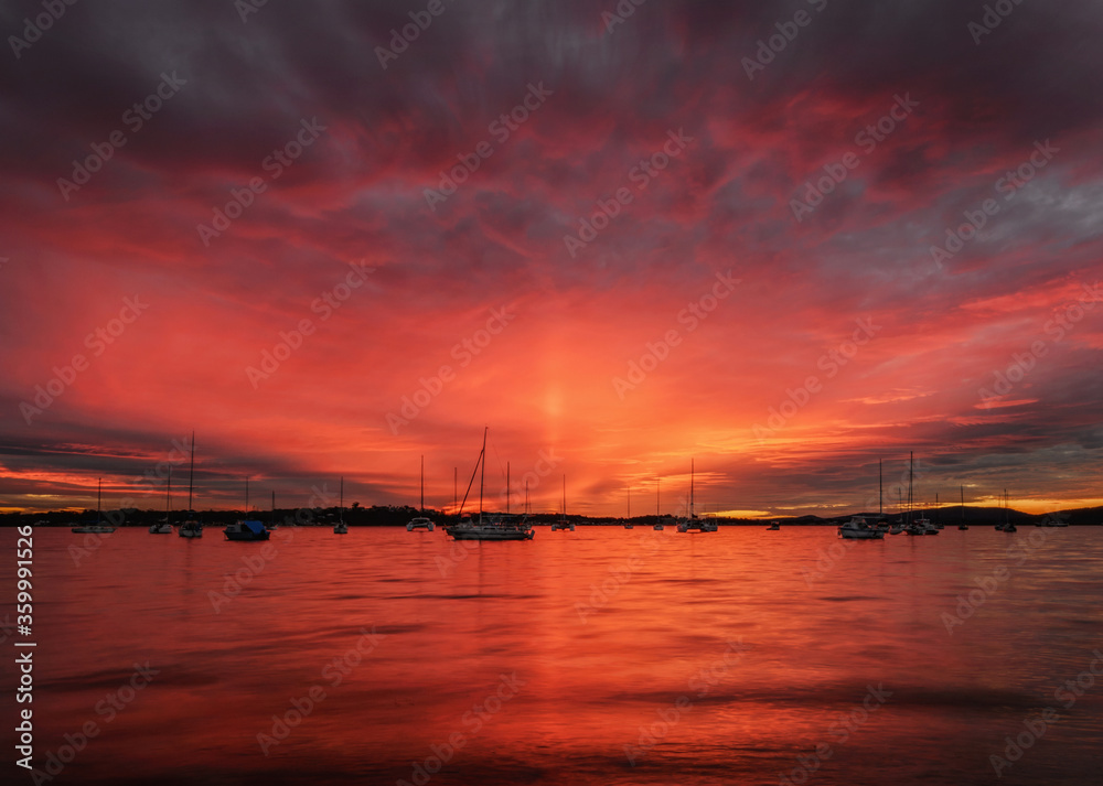 Dramatic red sunset behind yachts moored at Roy Wood Reserve, Port Stephens Dramatic red sunset behind yachts moored at Roy Wood Reserve, Port Stephens