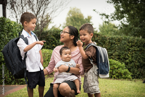 Mixed race boys say good-bye to their mum on their first day of school photo