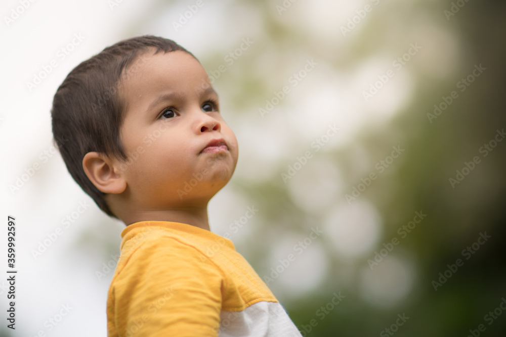 Serious looking 2 year old boy looking off into the distance Serious looking 2 year old boy looking off into the distance