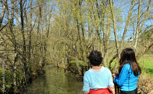 Two women hikers at Cereixo river in the forest near Laza, a village in the province of Ourense, Galicia, Spain photo