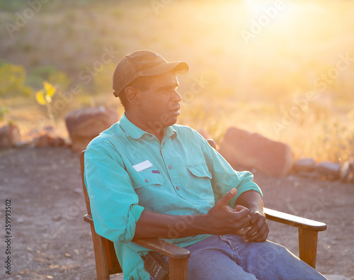 Young man sitting outdoors with sun flare photo