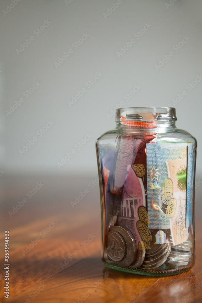 Australian money notes and coins in jar on wood with white copy space Australian money notes and coins in jar on wood with white copy space