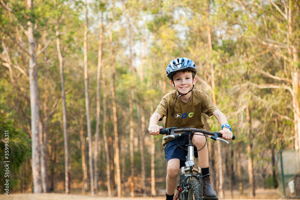 Happy boy riding bike in backyard with helmet on Happy boy riding bike in backyard with helmet on