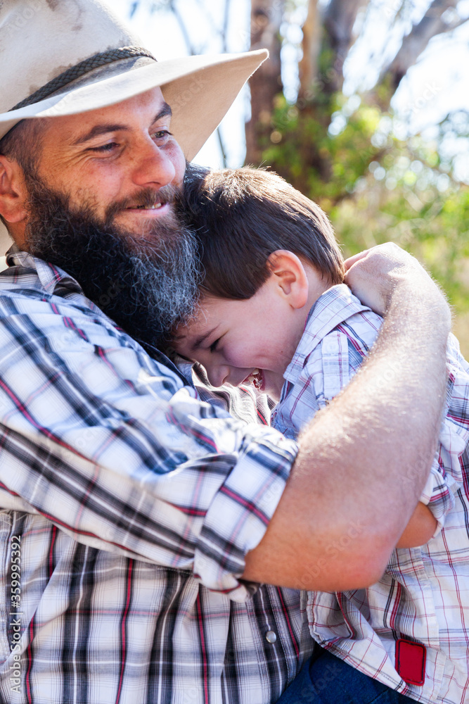 Father and young son hugging outside Father and young son hugging outside