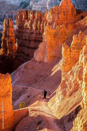 Bryce National Park, Utah, A photographer preparing to take a photo at sunset on a trail in Bryce National Park.