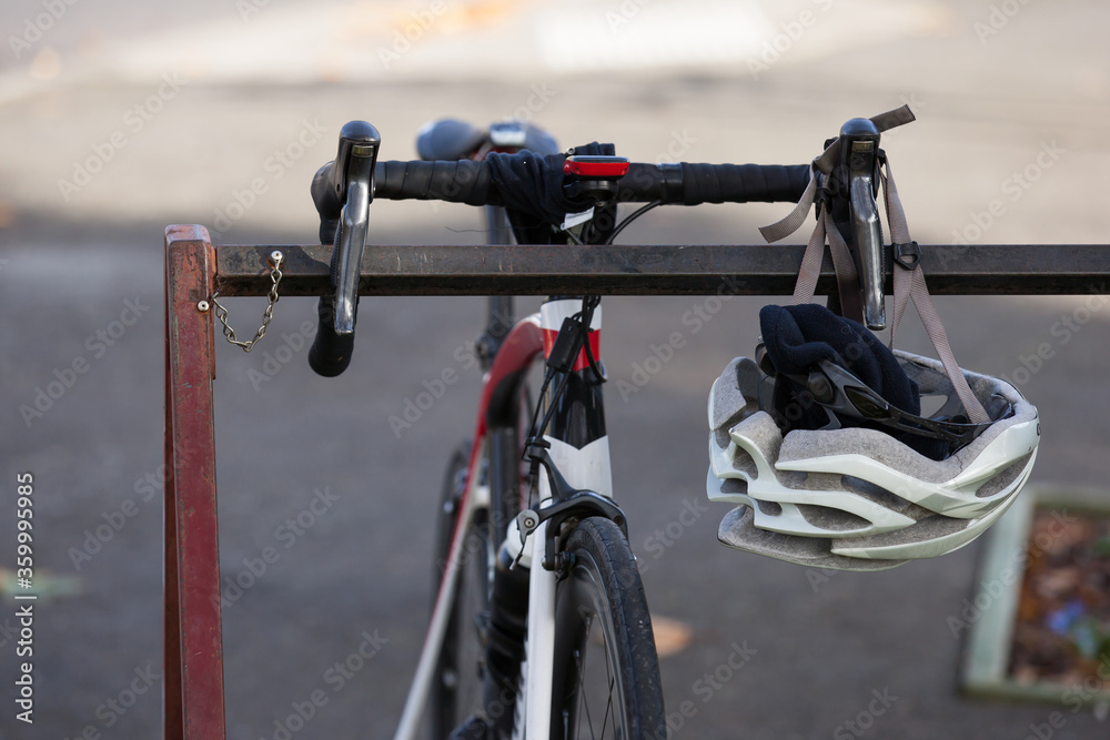 Bike sitting on rack with helmet hanging off handlebar Bike sitting on rack with helmet hanging off handlebar
