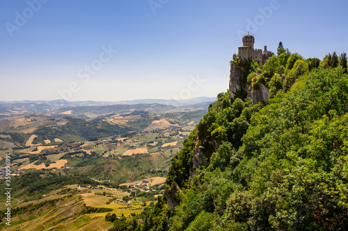 The old fortress stands on top of a mountain. View of the fortress and fields in the Republic of San Marino