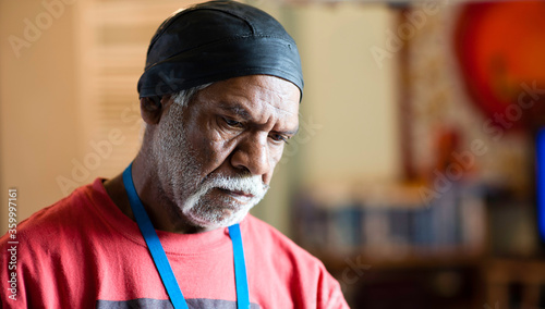 Wurundjeri Elder with Red Top Looking Downwards photo