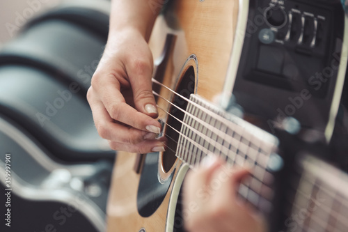 Close up of female hands playing an acoustic guitar photo