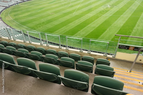 Empty stadium seats and a green afl oval photo