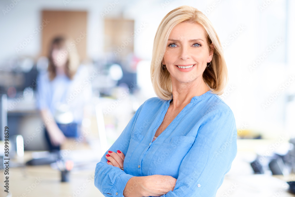 Attractive blond haired businesswoman portrait while standing in the office Attractive blond haired businesswoman portrait while standing in the office