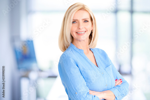 Attractive blond haired businesswoman portrait while standing in the office Free Download Attractive blond haired businesswoman portrait while standing in the office - GFXLoad