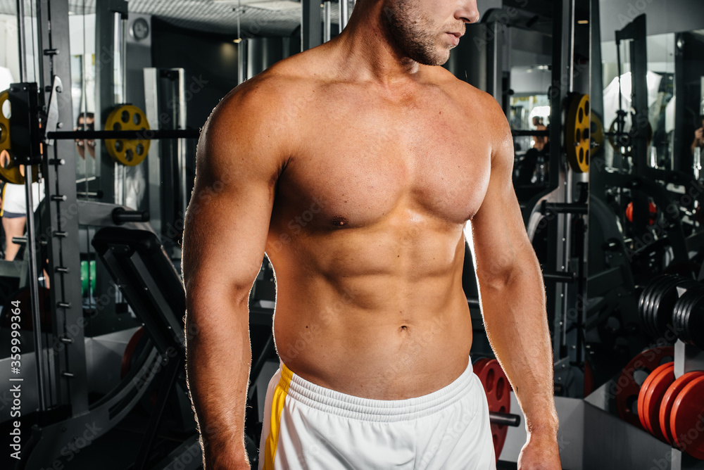 A young athletic guy is engaged in fitness in the gym. Fitness, bodybuilding A young athletic guy is engaged in fitness in the gym. Fitness, bodybuilding