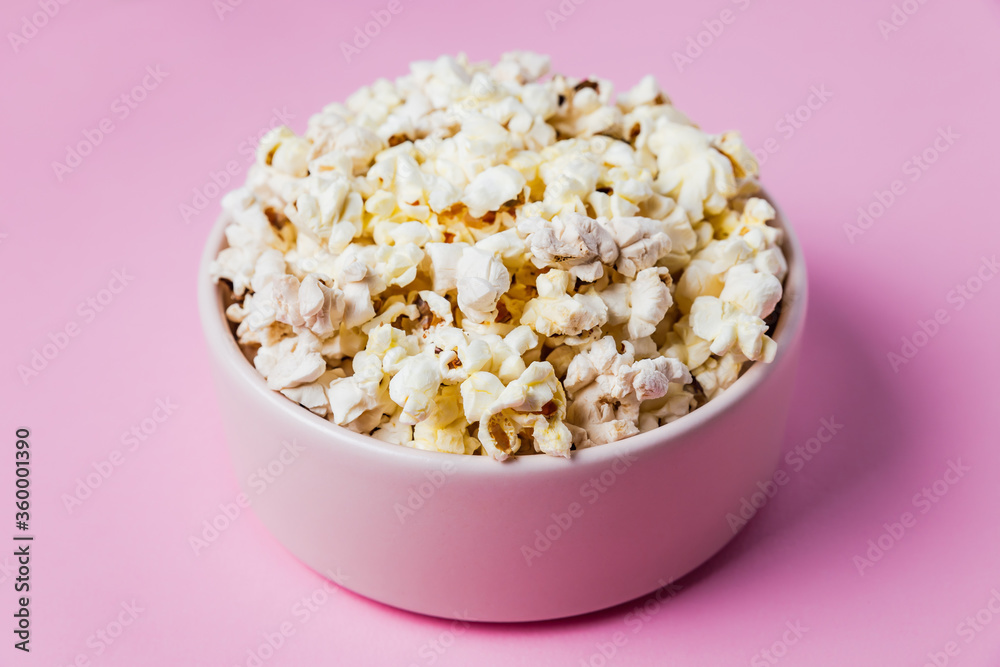 Close-up of a pink bowl of popcorn on pink background, top view Close-up of a pink bowl of popcorn on pink background, top view
