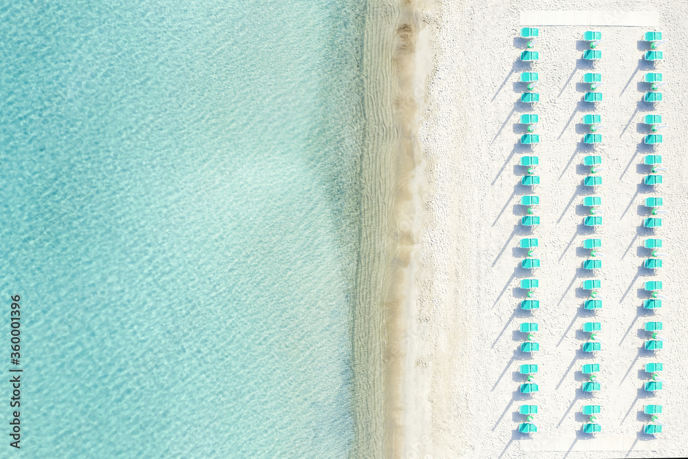 View from above, stunning aerial view of a white sand beach with beach umbrellas and a beautiful turquoise sea. Marinella Beach, Porto Rotondo,Sardinia, Italy.
