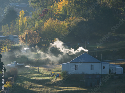 Farm house with smoke coming from chimney photo