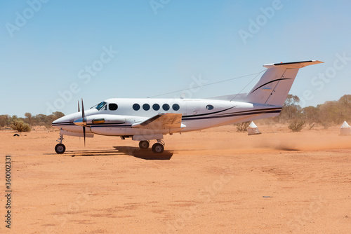 Small charter plane landing at remote air strip photo