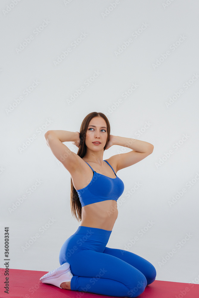 Sexy young girl performs sports exercises on a white background. Fitness, healthy lifestyle Sexy young girl performs sports exercises on a white background. Fitness, healthy lifestyle