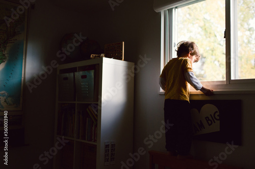 child looks out window photo