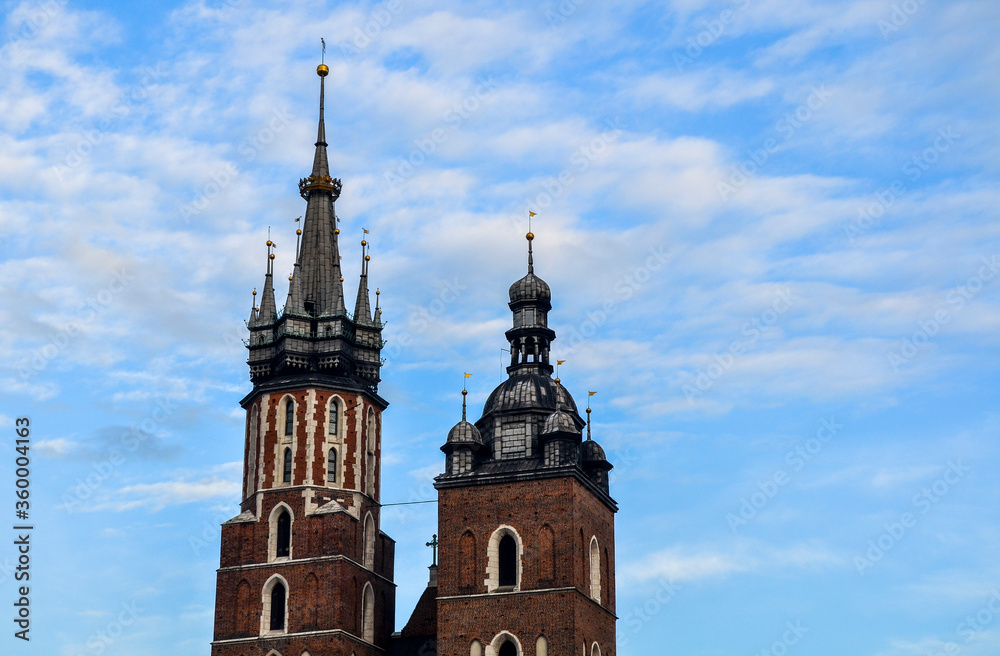 The two bell towers with spires of Saint Mary`s Church on main market square in Krakow, Poland The two bell towers with spires of Saint Mary`s Church on main market square in Krakow, Poland