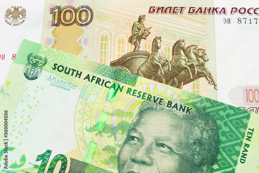 A macro image of a Russian one hundred ruble note paired up with a shiny, green 10 rand bill from South Africa.  Shot close up in macro.