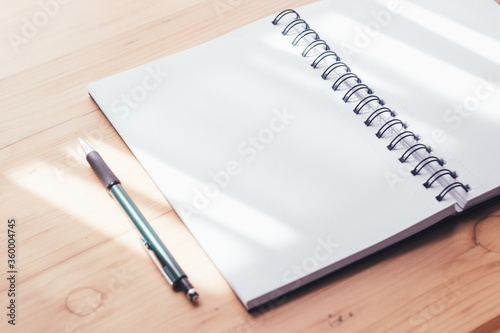 Close up. Beautiful open notebook with white pages on the wooden table. Notebook, planning, morning, day, sunny, table. Morning, sunny day. Planning and work concept.