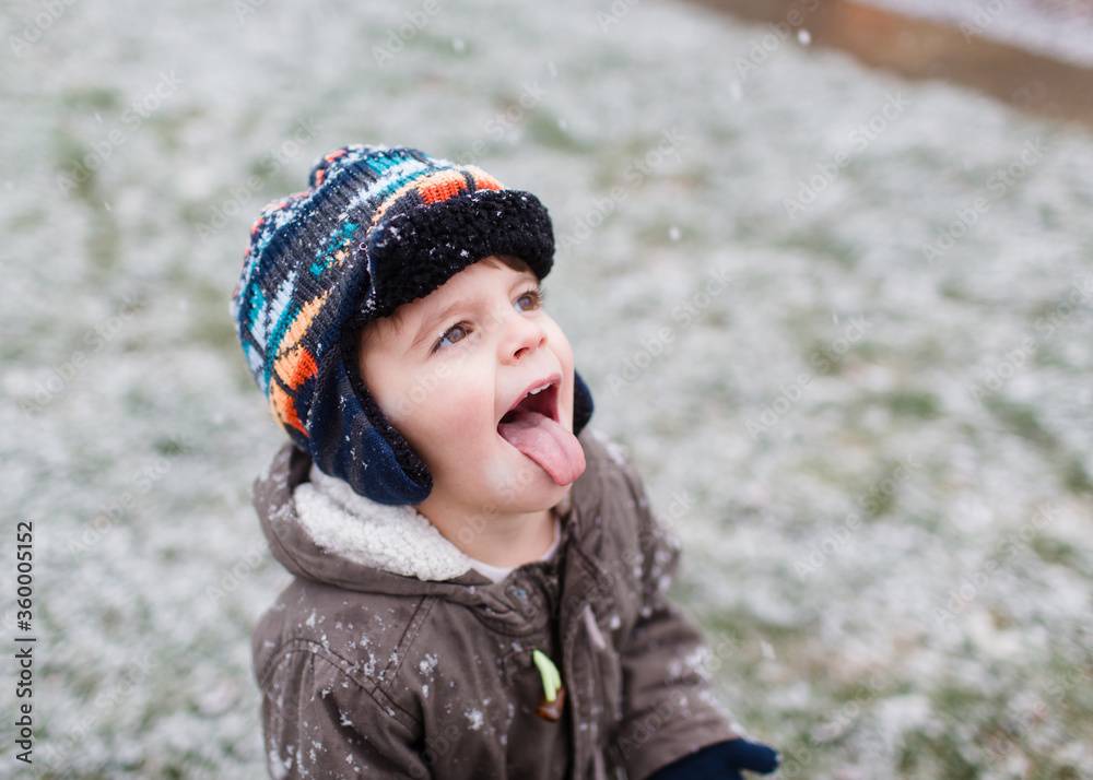 little boy catches snowflakes on tongue little boy catches snowflakes on tongue