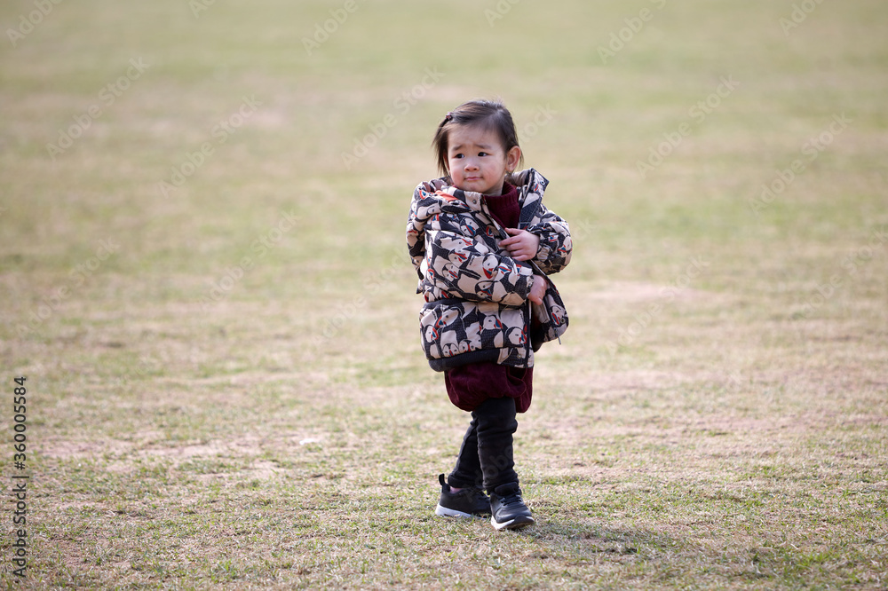Asian little girl playing in the stadium in winter outdoor