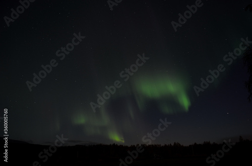 aurora borealis dancing on the night sky in autumn