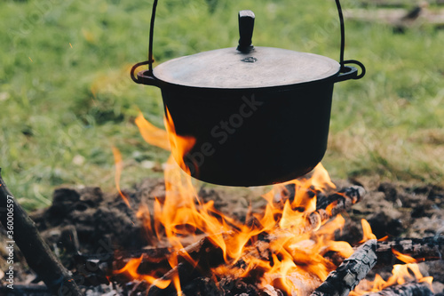 bowl on a campfire on a background of grass