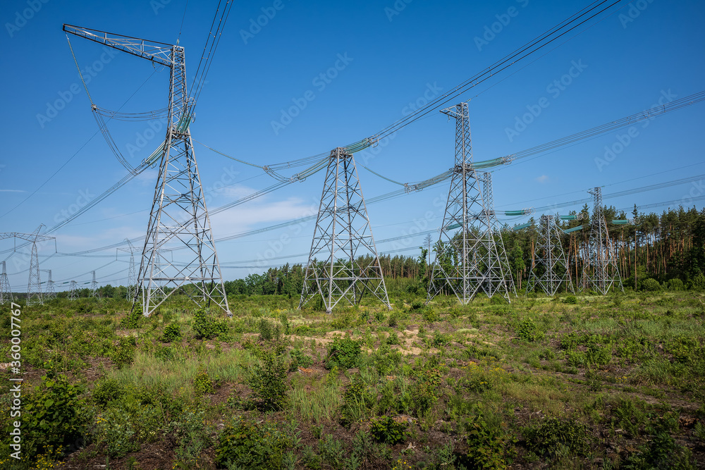 High-voltage electric poles against a cloudy sky