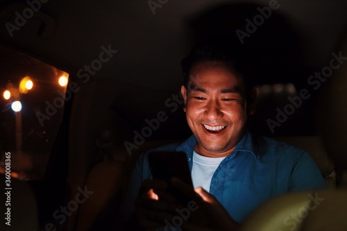 man using smart phone in car.