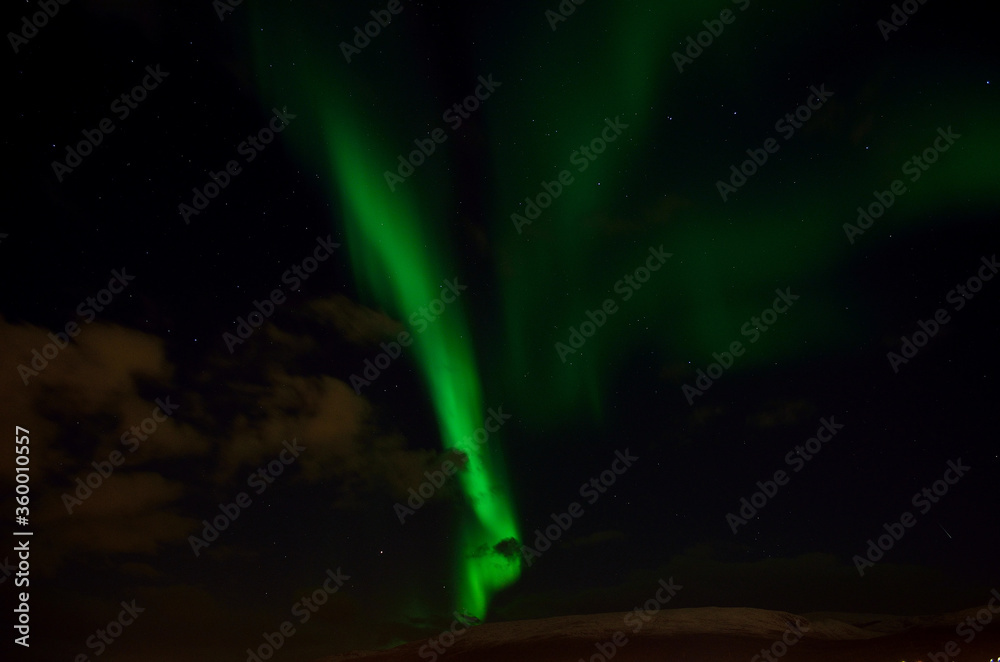 Obraz premium strong aurora borealis over snowy mountain in autumn