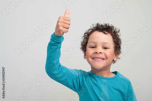 boy showing thumbs up gesture on white grey background stock photo