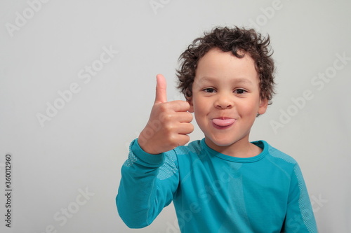 boy showing thumbs up gesture on white grey background stock photo
