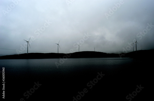 windmill on mountain top on dark and rain heavy summer day