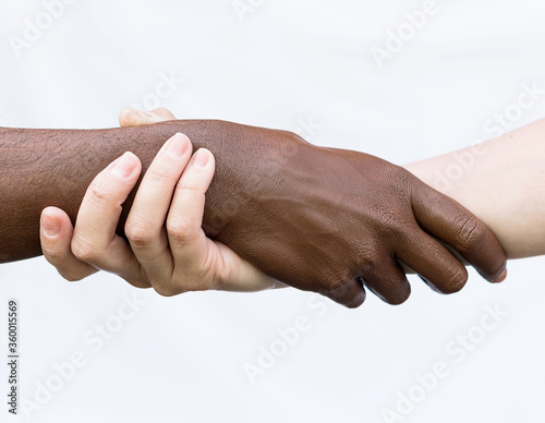 Black-and-white human arms wrapped around each other. The concept of combating racism, of community, friendship, equality