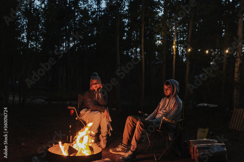 Camp fire in the forest. Sitting by the fire. Relax and leisure. National park forest. Two people campers are on vacation. Road trip vacation. Local traveling. Camping season. Fourth of July.