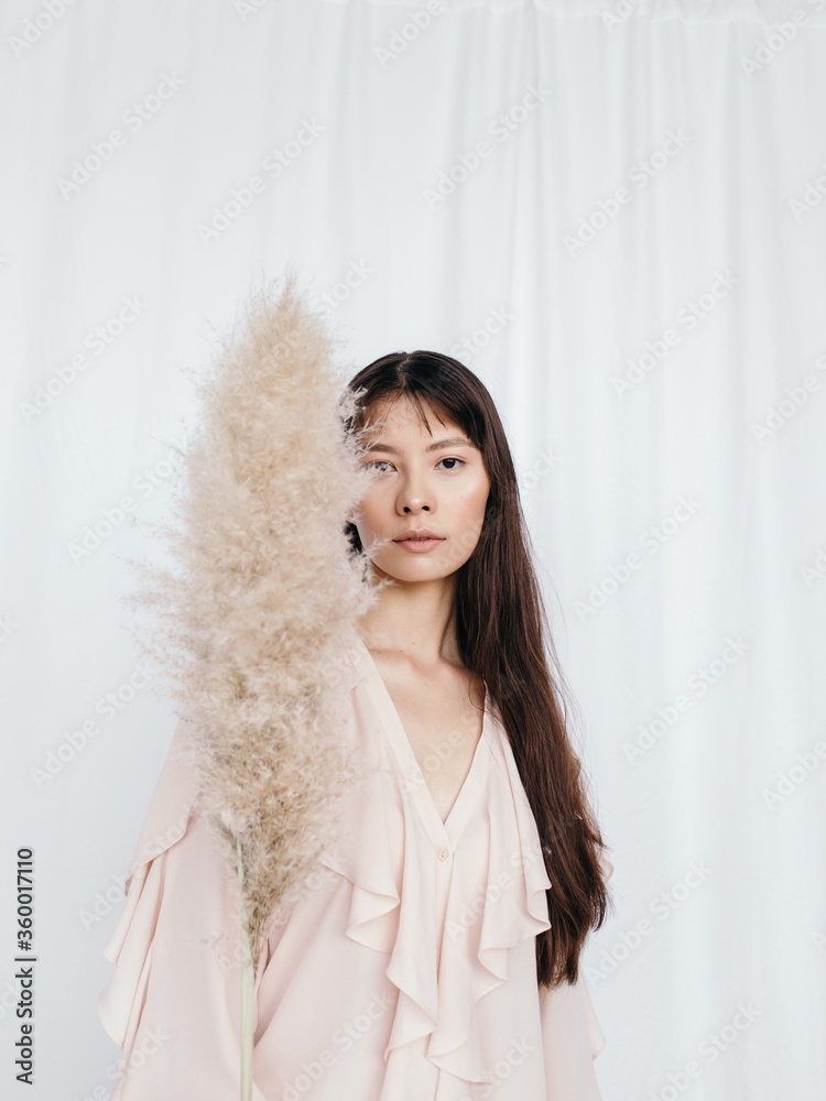 Ethnic woman hide face with soft fan