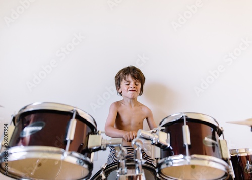 child rocks out on drumset