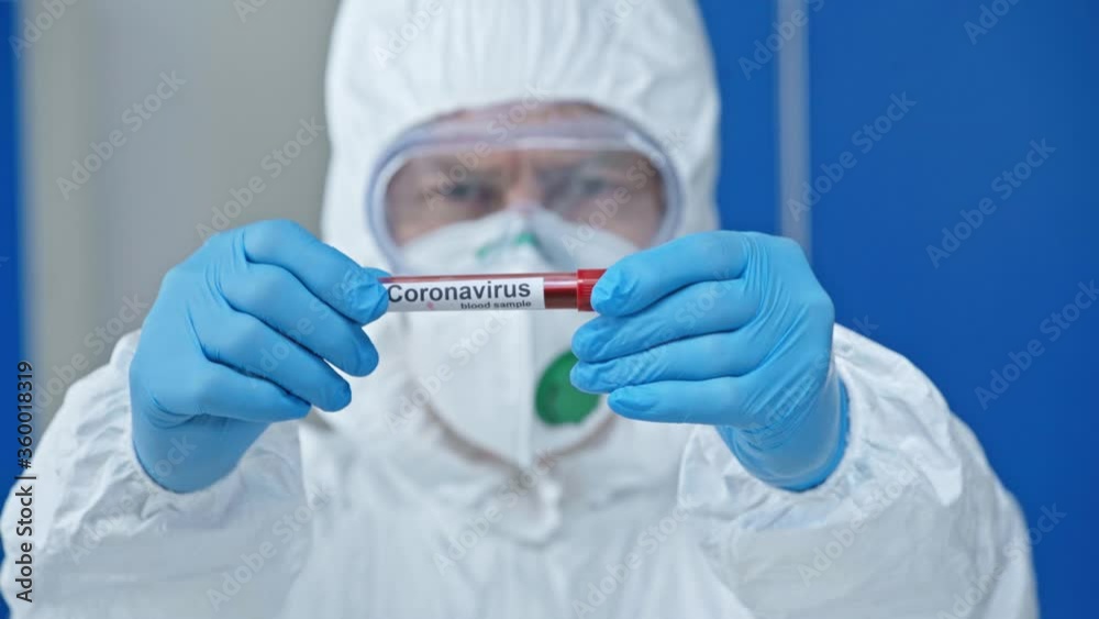 selective focus of male scientist holding test tube with coronavirus lettering selective focus of male scientist holding test tube with coronavirus lettering